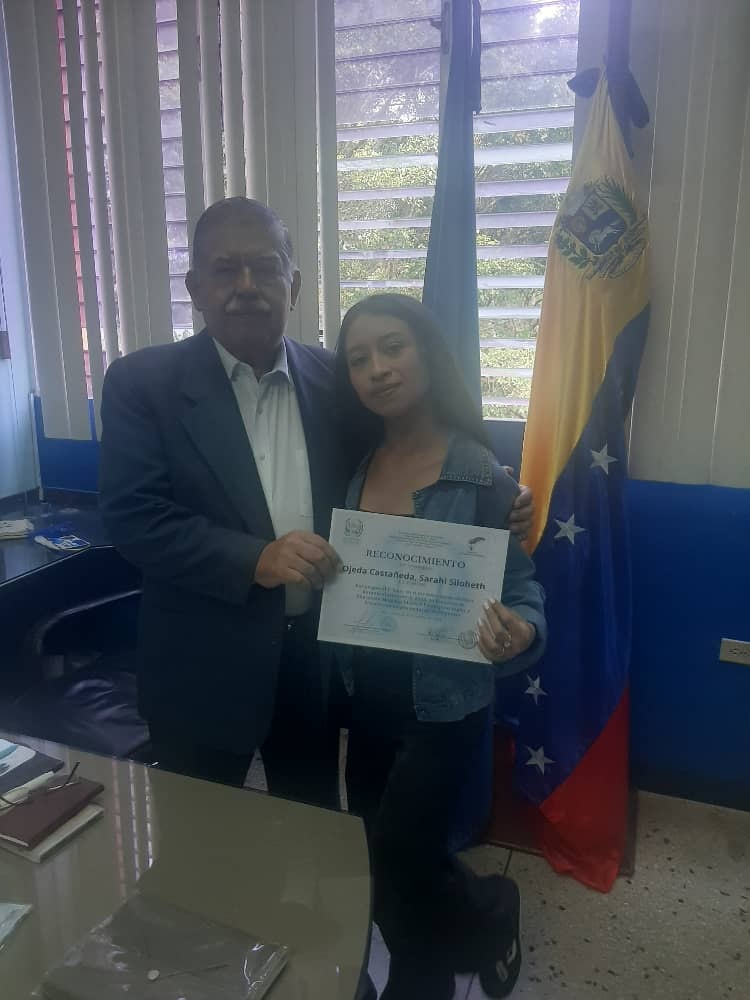 El vicerrector de la ULA Omar Pérez Díaz con la estudiante que tiene el promedio más alto, 19, 20 Sarahi Ojeda Castañeda.